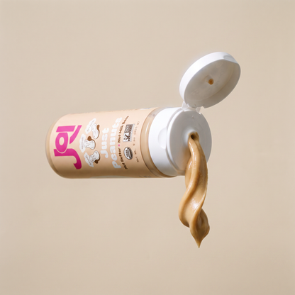 A squeeze tube of Joy Juice Protein Powder with the cap open, showing a swirl of tan protein powder dripping out against a solid beige background.